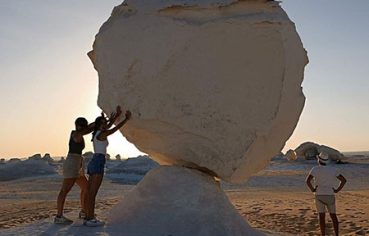 Two travelers posing with a massive white rock formation during a 12 day egypt bahariya oasis tour