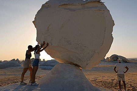 Two travelers posing with a massive white rock formation during a 12 day egypt bahariya oasis tour