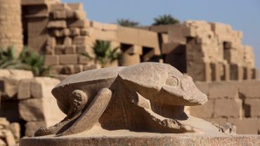 An Egyptian scarab symbolizes rebirth and protection. It is often depicted as a carved amulet, representing the sacred dung beetle in ancient Egypt.