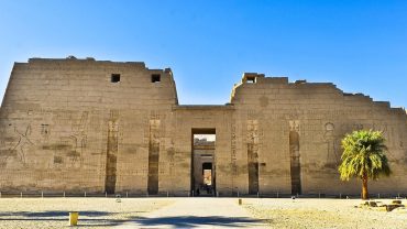 A detailed view of the magnificent Medinet Habu Temple, showcasing the intricate carvings and hieroglyphics on its ancient walls.