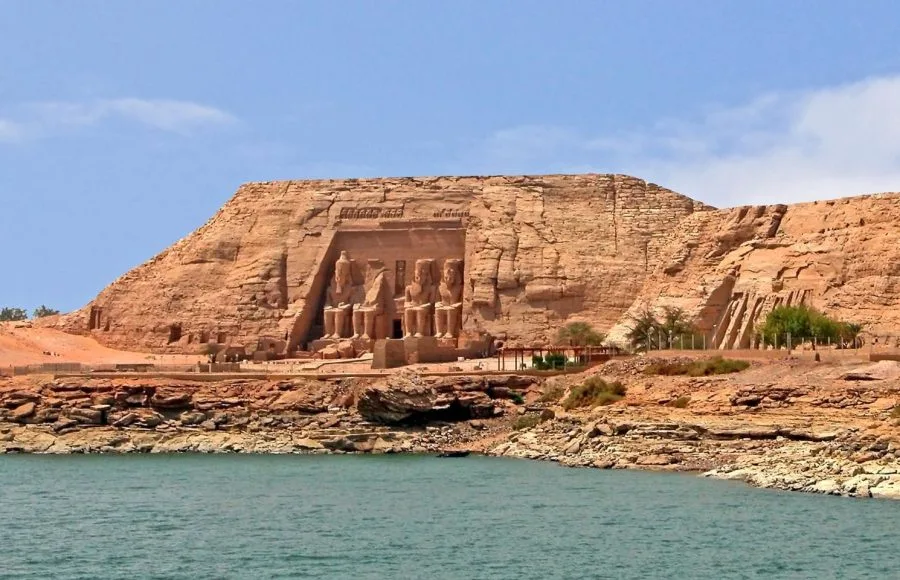The Great Temple of Ramesses II at Abu Simbel, carved into the cliff face, viewed across the water of Lake Nasser, often visited on a tour from Aswan.