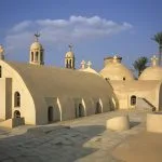 View of the domed rooftops and bell towers of Al Baramus Monastery in Wadi El Natrun.