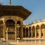 The intricately carved ablution fountain in the courtyard of the Mosque of Muhammad Ali Pasha in Cairo, under a clear sky.