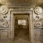 Entrance to the Catacombs of Kom El Shoqafa in Alexandria with relief sculptures of serpentine creatures.