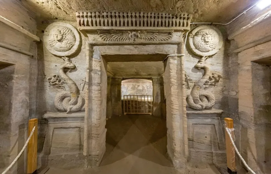 Entrance to the Catacombs of Kom El Shoqafa in Alexandria with relief sculptures of serpentine creatures.