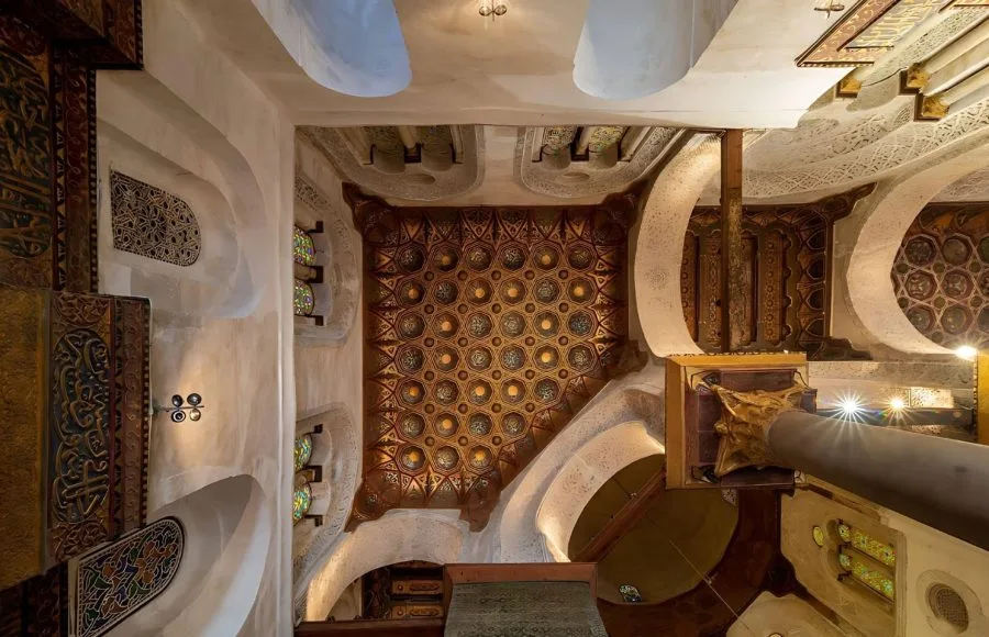 An upward view of the highly detailed, ornate wooden and geometric Ceiling of Mausoleum of Sultan Qalawun, showing painted designs and intricate craftsmanship in Islamic Cairo.