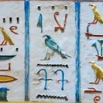 An intricate close-up of the well-preserved Colorful Hieroglyphs Paintings in Ramses IV Tomb Valley of The Kings, showing vivid bird, plant, and symbol designs.