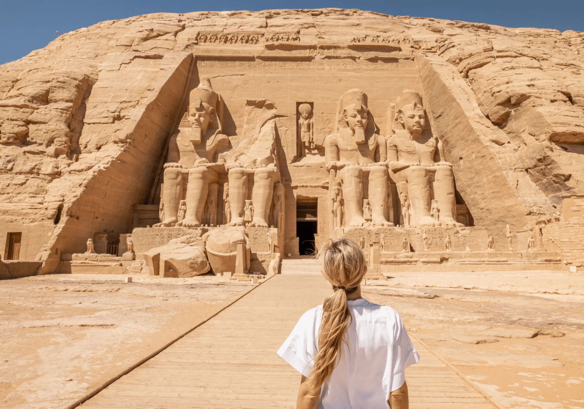 A woman looking at Abu Simbel Temple in the background