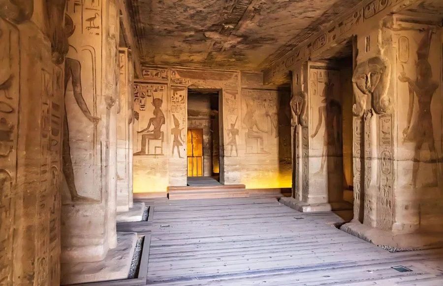 The interior of the Inside the Small Temple of Ramesses II Abu Simbel, showing columns carved with the likenesses of Queen Nefertari, and well-preserved reliefs and hieroglyphics on the walls.