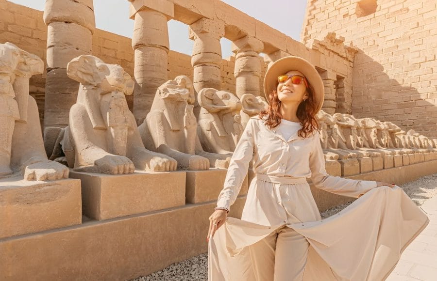 Woman tourist exploring the Avenue of Sphinxes in Karnak Temple Luxor Egypt ancient architecture