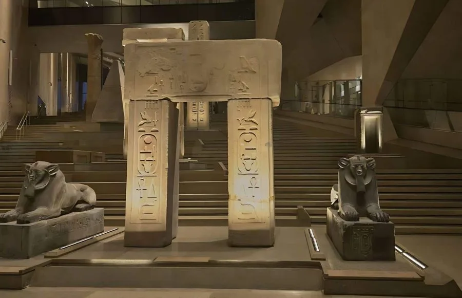 Massive ancient Egyptian statues and artifacts on display in the brightly lit, modern entrance hall during The Grand Egyptian Museum Tour.