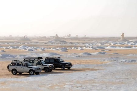 Three 4X4 Jeeps Parked Among The White Chalk Formations Of The White Desert In Bahariya, Egypt.