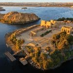An aerial View of The temple of philea in egypt, showing the complex of buildings relocated on Agilkia Island, surrounded by the deep blue waters of the Nile.
