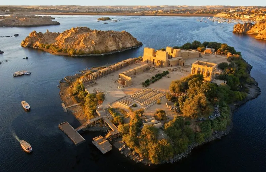 An aerial View of The temple of philea in egypt, showing the complex of buildings relocated on Agilkia Island, surrounded by the deep blue waters of the Nile.