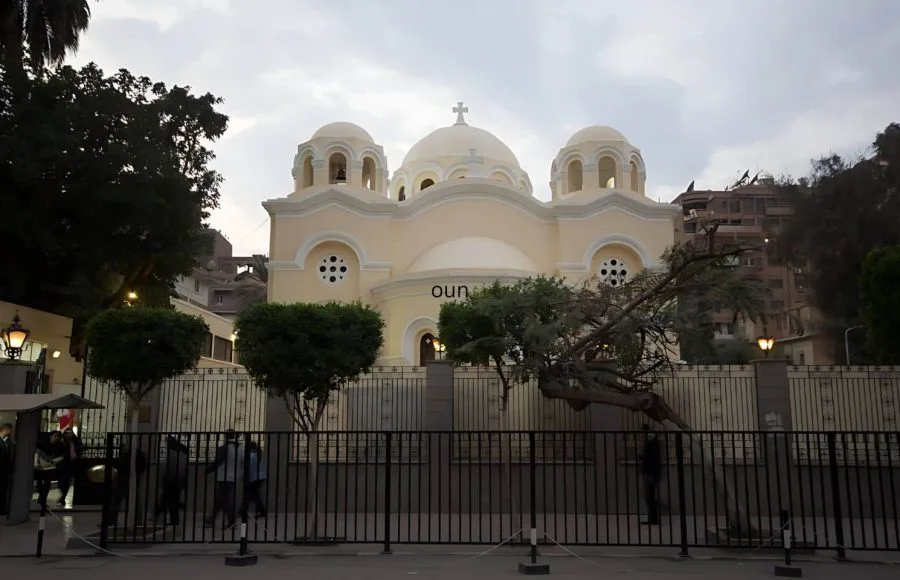 The exterior facade of the Virgin Mary Church Zaitoun in Cairo with multiple domes and a cross.