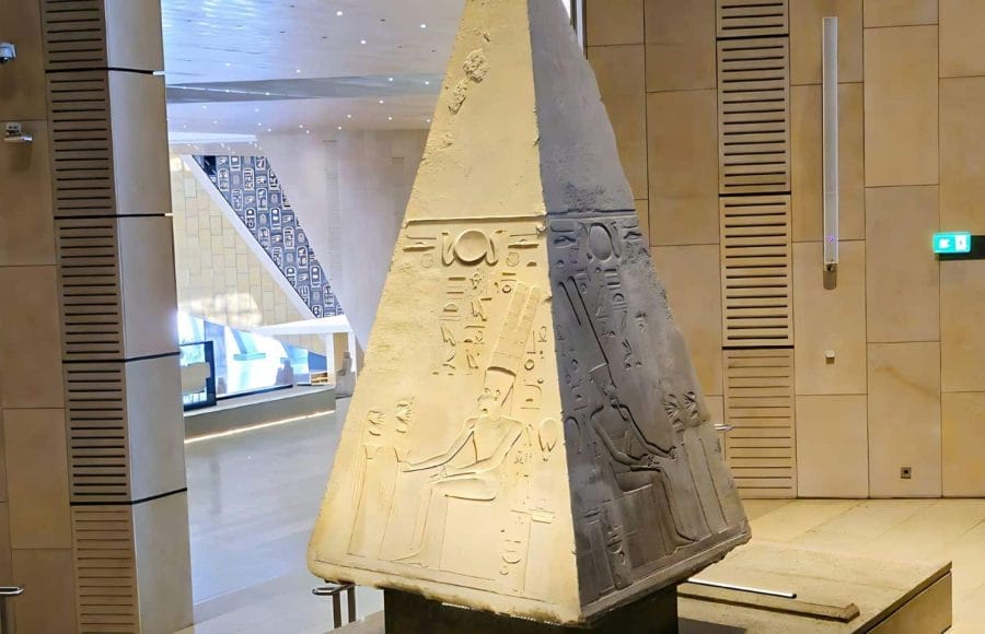 Ancient granite pyramidion capstone with hieroglyphs on display inside the Grand Egyptian Museum GEM Giza