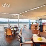 The shaded sun deck bar and seating area overlooking the Nile on the luxurious MS Miriam nile cruise ship