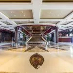 The spacious and well-lit lobby of the Blue Shadow 2 Nile Cruise features a reception desk and a staircase leading to the upper deck.
