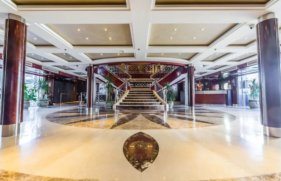The spacious and well-lit lobby of the Blue Shadow 2 Nile Cruise features a reception desk and a staircase leading to the upper deck.