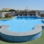 The sparkling swimming pool on the sun deck of the Blue Shadow i Nile Cruise, surrounded by lounge chairs.
