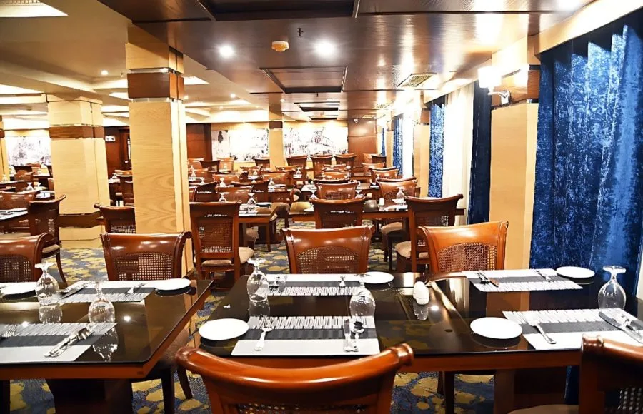 The dining room on the MS Blue Shadow II Nile cruise ship, with multiple tables set for a meal.