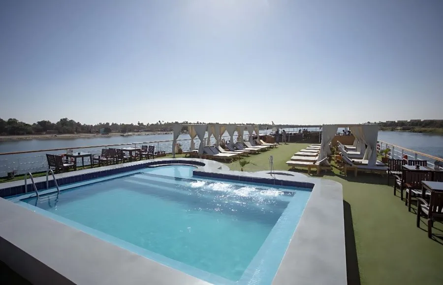 The sunny top deck of the Blue Shadow II Nile cruise ship, showing a swimming pool and lounge chairs.