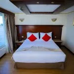 A luxurious double cabin on the Ms Blue Shadow iii Nile Cruise with a king-size bed and a panoramic window overlooking the Nile.