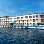The majestic HS Solaris I Nile Cruise ship gracefully sailing on the Nile River under a clear blue sky, showcasing its elegant exterior.