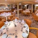 A well-appointed restaurant on the HS Solaris I Nile Cruise with neatly set tables and a buffet station, ready to serve a variety of delicious meals.