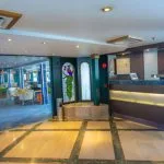 The elegant reception and lobby area of the Solaris II Nile Cruise, featuring a modern front desk with a staff member and a view into the stylish lounge