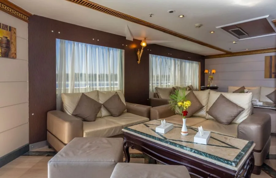 The inviting and comfortable lounge area on the Solaris II Nile Cruise, featuring plush sofas, elegant decor, and large windows offering river views