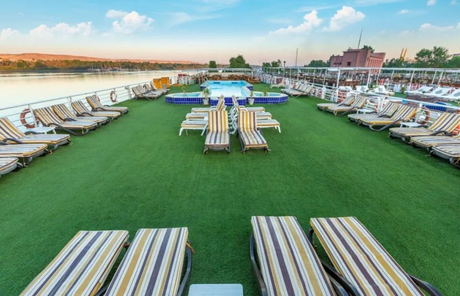 The expansive sundeck on the Solaris II Nile Cruise, featuring a central hot tub, multiple sun loungers, and stunning panoramic views of the Nile River