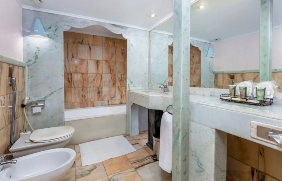 The well-appointed bathroom on the Solaris II Nile Cruise, featuring a full bathtub, a spacious marble vanity with two sinks, and a clean, elegant design