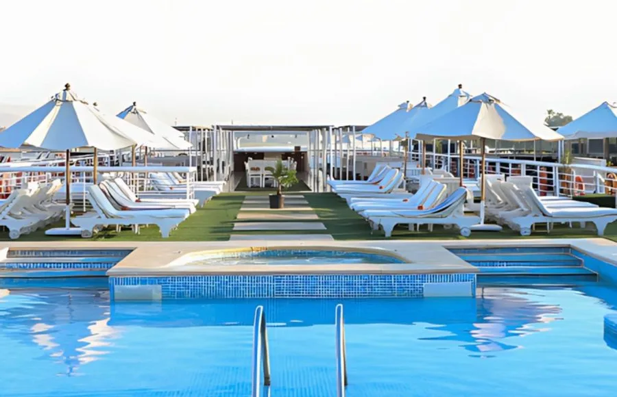 A refreshing swimming pool on the sun deck of the MS Al Jamila Nile Cruise ship, surrounded by comfortable lounge chairs and umbrellas