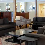 The inviting lounge area of the Al Kahila Nile cruise with plush sofas and a well-stocked bar in the background.