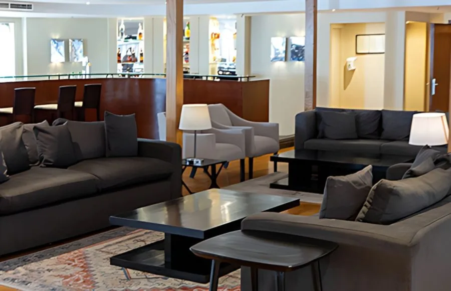 The inviting lounge area of the Al Kahila Nile cruise with plush sofas and a well-stocked bar in the background.