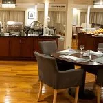 The inviting restaurant on the Al Kahila Nile cruise, featuring a buffet area and elegantly set dining tables.