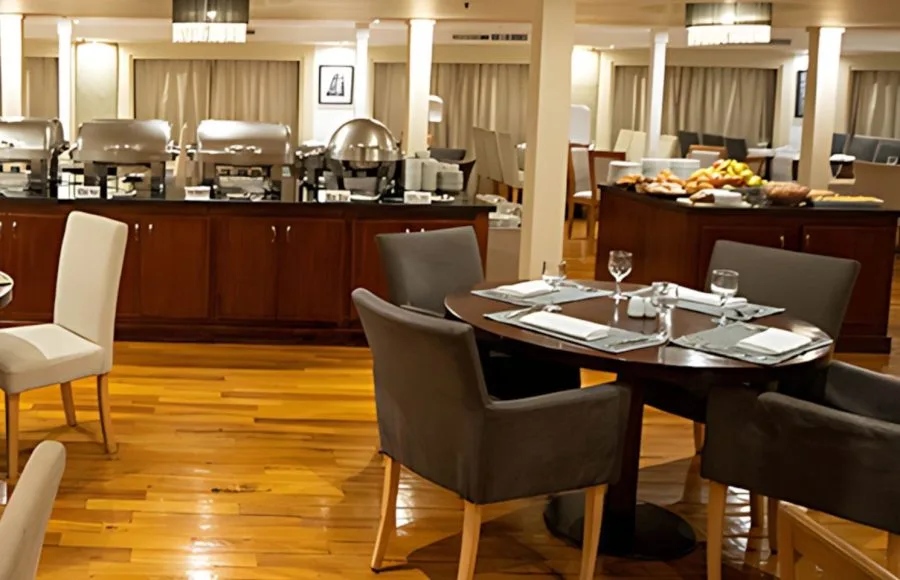 The inviting restaurant on the Al Kahila Nile cruise, featuring a buffet area and elegantly set dining tables.