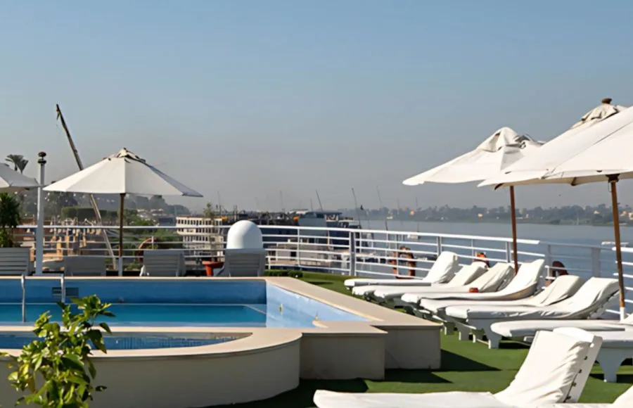 Relax aboard the luxurious Al Kahila Nile cruise ship with stunning deck views, a sparkling pool, and comfortable sun loungers perfect for soaking up the Egyptian sun.