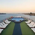 The sun deck of the MS Concerto II with a swimming pool surrounded by sun loungers.
