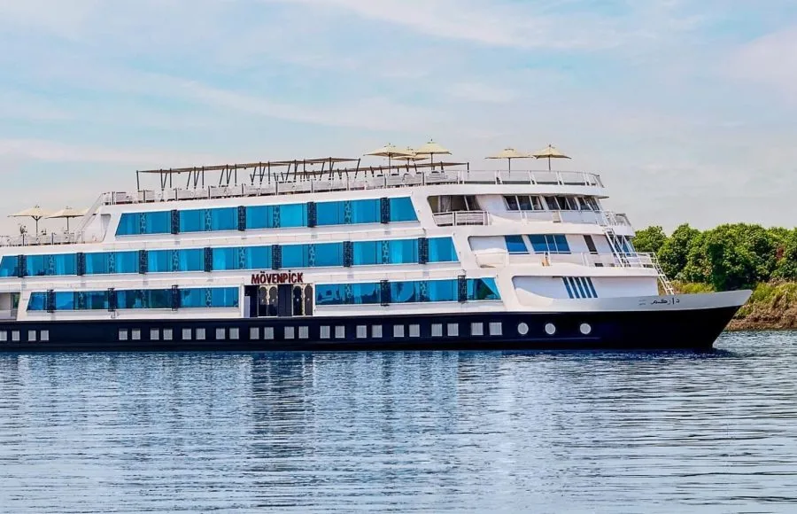 The elegant exterior of the Movenpick MS Darakum Nile Cruise prominently displays the Movenpick logo with multiple decks of cabins and a sunny top deck for leisure