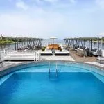The spacious sun deck of the Movenpick MS Darakum Nile Cruise features a refreshing circular swimming pool surrounded by comfortable loungers and umbrellas perfect for relaxing along the river
