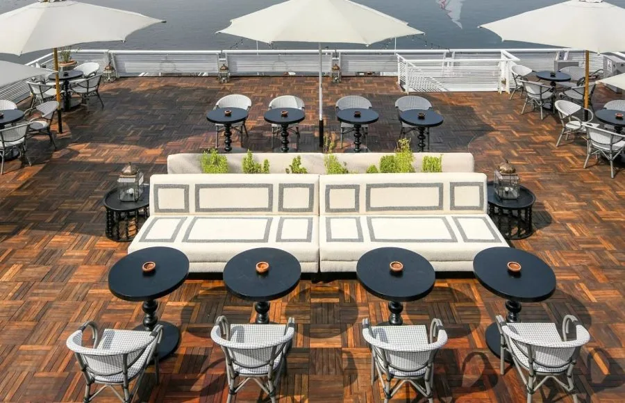 The inviting outdoor lounge area of the Movenpick MS Darakum Nile Cruise offers stylish seating and shaded tables perfect for enjoying the views and socializing on the Nile