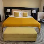 A comfortable and elegantly designed cabin on the Ms Farida Nile cruise with a large bed and yellow accents.
