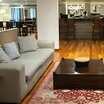 Relax in the elegant lounge area of the MS Farida Nile Cruise, featuring comfortable seating and a stylish bar in the background for guests to enjoy.