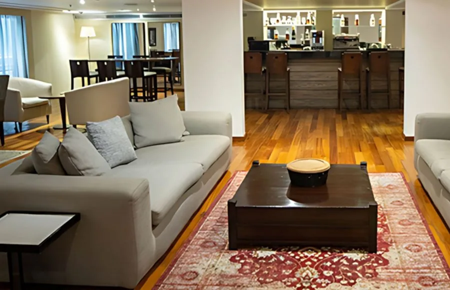 Relax in the elegant lounge area of the MS Farida Nile Cruise, featuring comfortable seating and a stylish bar in the background for guests to enjoy.