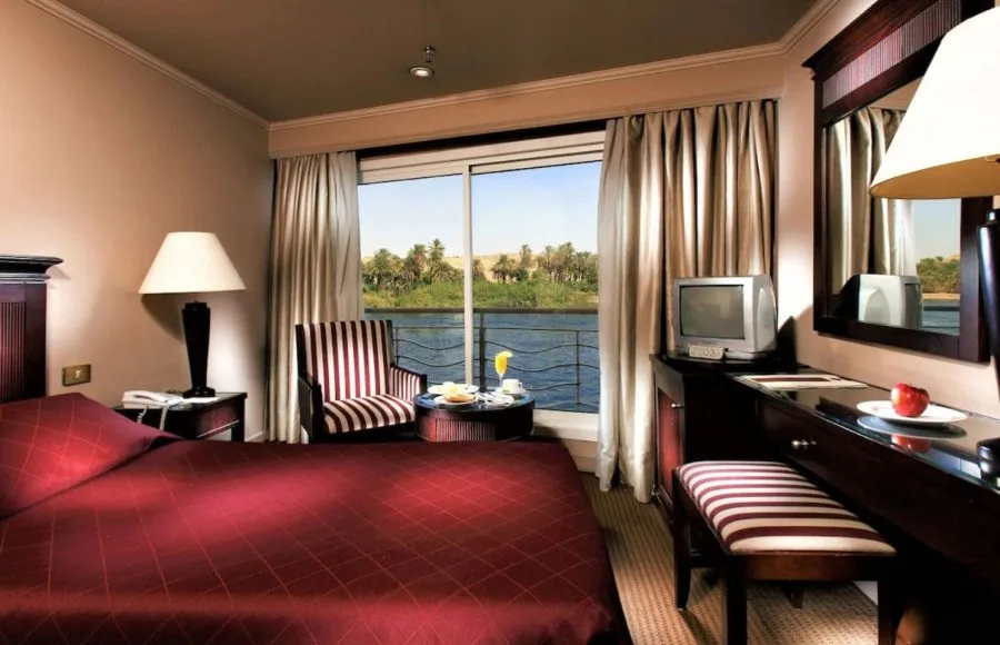 Suite with a double bed and a Nile view on the Jaz Crown Jubilee Nile Cruise.