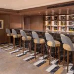A modern and stylish bar on the MS Jaz Regent Nile Cruise, with high chairs and a sophisticated decor.