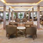 The spacious and well-lit lounge area on the MS Jaz Regent Nile Cruise, featuring comfortable armchairs and sofas arranged in inviting seating groups.