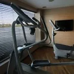 The gymnasium of the MS Le Fayan, including a cross-trainer and stationary bike.